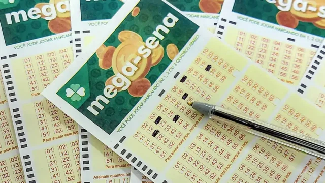 Volantes de apostas da Mega-Sena preenchidos com caneta sobre mesa