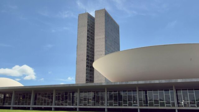Fachada da sede do Congresso Nacional em Brasília com o espelho d'água em primeiro plano