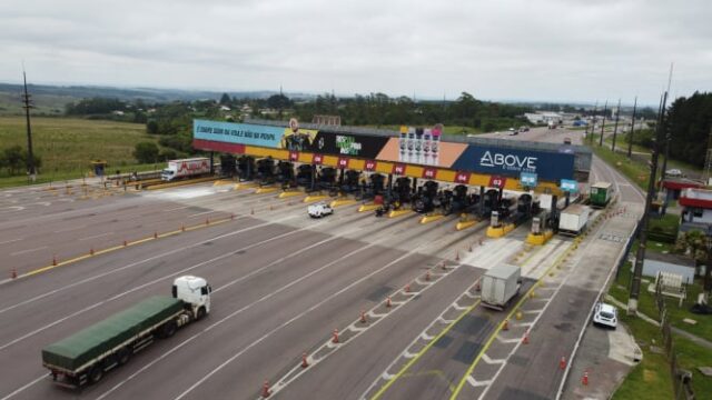 Vista aérea de praça de pedágio em rodovia no Paraná com fluxo de veículos e caminhões