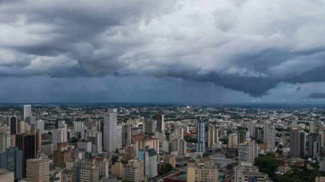 Vista panorâmica de prédios urbanos sob céu nublado e ameaça de chuva