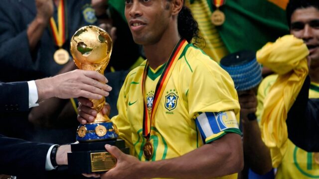 Ronaldinho Gaúcho segurando o troféu da Copa do Mundo vestindo a camisa da seleção brasileira