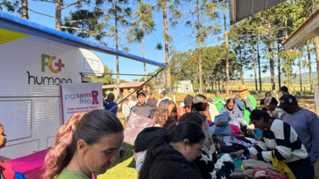 Pessoas escolhendo roupas e atendimento em tenda durante a Ação Conecta FASPG nos Bairros no Ouro Verde