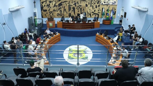 Vista geral do plenário da Câmara Municipal de Ponta Grossa com vereadores e público acompanhando a sessão