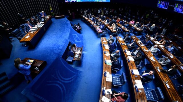 Vista superior do plenário do Senado Federal com parlamentares sentados às mesas durante sessão