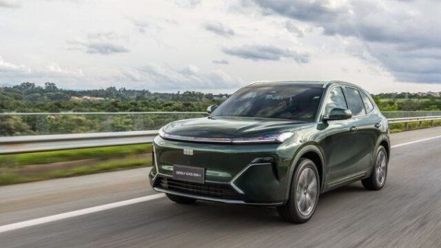 Carro SUV verde Geely EX5 EM-i rodando em rodovia pavimentada sob céu nublado