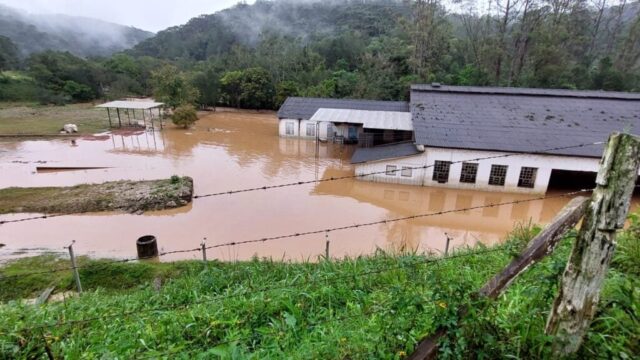 Área rural alagada com construções parcialmente submersas pela água da chuva em Castro