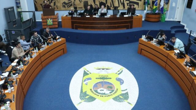 Vista superior do plenário da Câmara Municipal de Ponta Grossa com vereadores sentados às mesas durante sessão