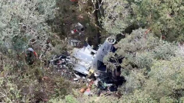 Vista aérea dos destroços de um helicóptero espalhados em área de vegetação densa