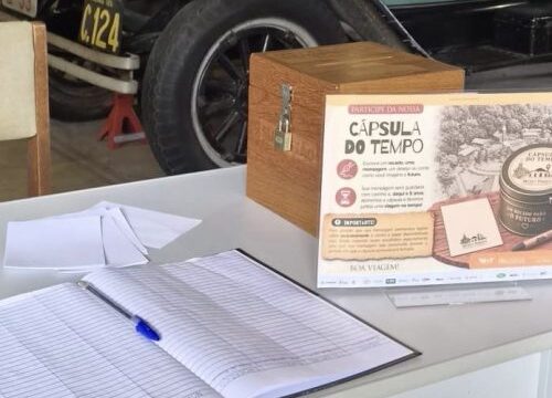 Mesa com livro de assinaturas, caneta e urna de madeira para Cápsula do Tempo em museu