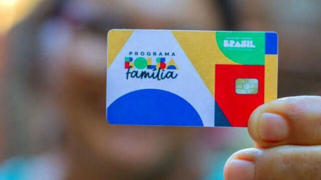 Pessoa exibe cartão físico do programa Bolsa Família com chip dourado