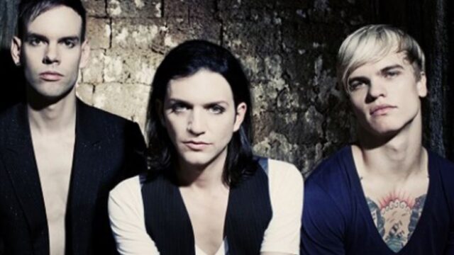 Integrantes da banda Placebo posam para foto promocional com visual característico