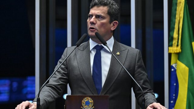 O senador Sergio Moro veste terno e gravata enquanto discursa na tribuna do Senado Federal em Brasília