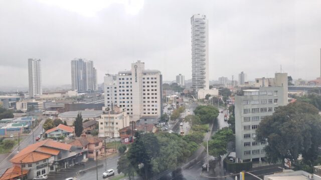 Vista aérea de Ponta Grossa em dia nublado com edifícios e ruas molhadas