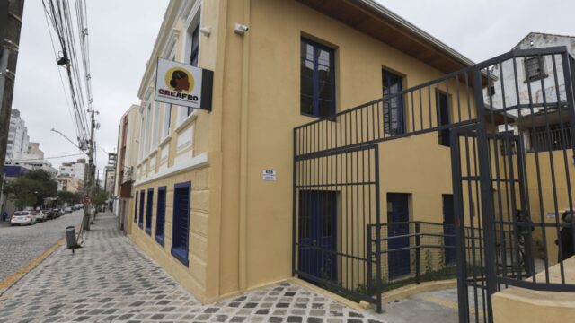 Fachada do edifício do Creafro em Curitiba com paredes em tons de amarelo e portas e janelas azuis