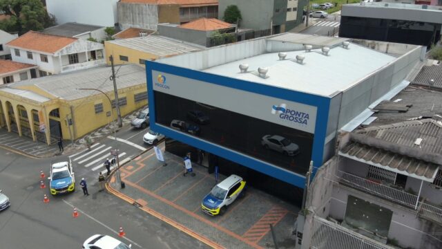 Vista aérea da fachada e da entrada da nova sede do Procon Ponta Grossa, com veículos estacionados em frente