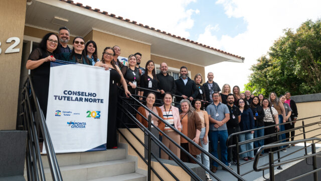 Grupo de pessoas em frente à fachada do prédio na inauguração da nova sede do Conselho Tutelar Norte