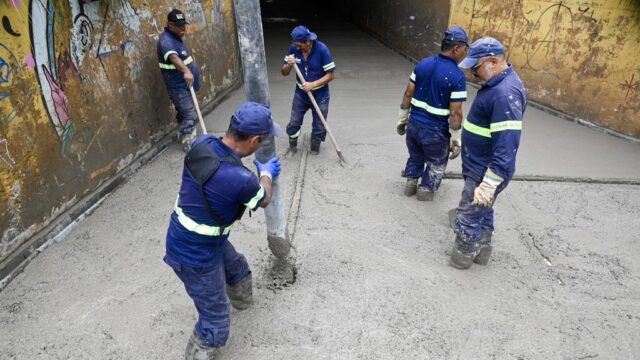Equipe de operários em serviço de concretagem no piso do Túnel do San Martin