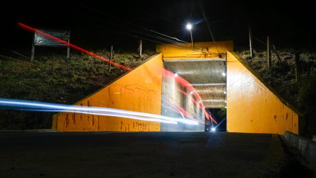 Túnel do San Martin iluminado à noite com rastros de luz de veículos em Ponta Grossa