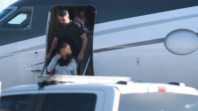 Flávio Bolsonaro descendo a escada de uma aeronave particular em aeroporto ao lado de familiares