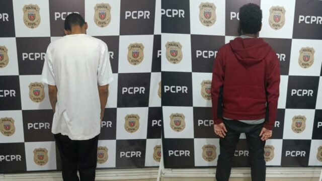 Dois homens de costas em delegacia com fundo quadriculado da Polícia Civil em Cascavel