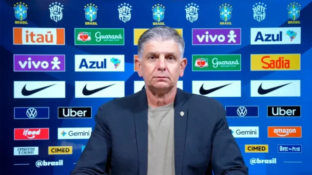 Treinador Guilherme Dalla Déa diante de painel com marcas patrocinadoras da Seleção Brasileira