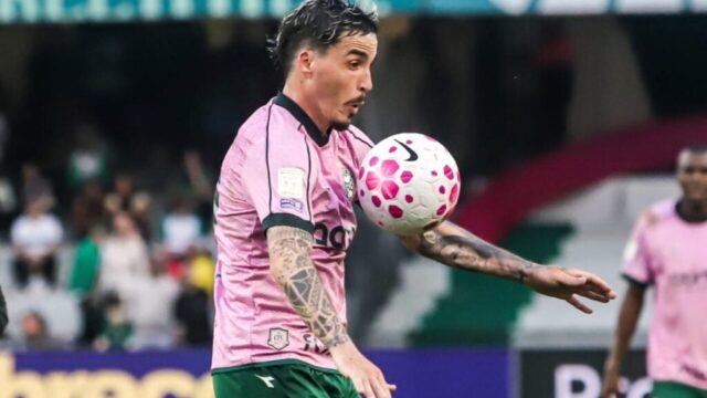 O jogador Josué domina a bola vestindo o uniforme rosa e verde do Coritiba em partida de futebol