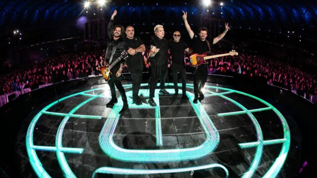Banda Jota Quest se apresentando em show no palco com iluminação neon no chão