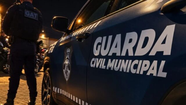 Viatura da Guarda Civil Municipal estacionada à noite com agente de costas no cenário da ocorrência