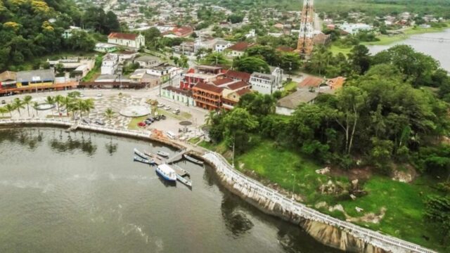 Vista aérea da cidade de Guaraqueçaba, no litoral do Paraná, mostrando praça, construções e área de atracação de barcos