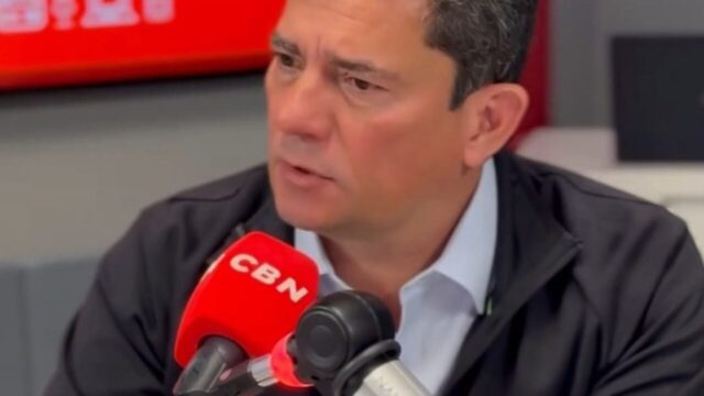 Sergio Moro gesticula enquanto participa de entrevista sentado em estúdio com microfone da CBN