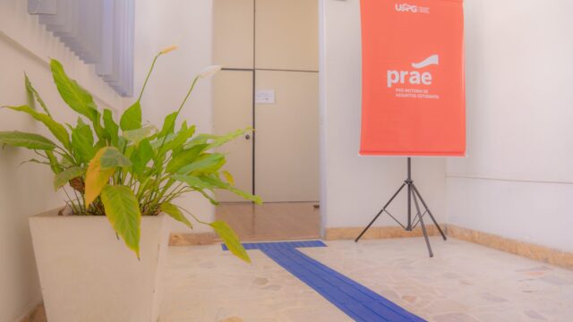 Banner da Prae da UEPG instalado no corredor próximo à sala de atendimento no Campus Centro