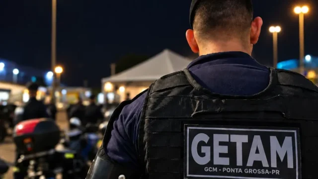 Agente da Guarda Civil Municipal com colete tático escrito GETAM e GCM Ponta Grossa PR